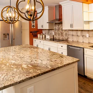 Granite kitchen island with custom cabinetry and pendant chandeliers