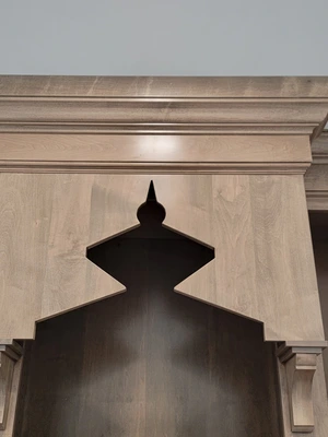 Close-up of hand-carved wood shrine arch with decorative finial in custom prayer room Downingtown, PA
